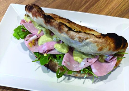 panuozzo pistache Sandwich au pain croustillant garni de jambon, roquette et sauce.