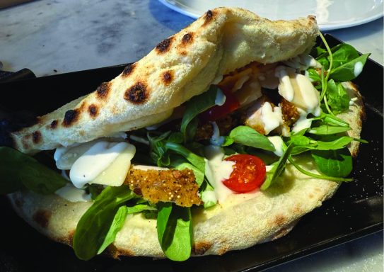 panuozzo cesar Sandwich plat typique, rempli de légumes frais et de feta, servi sur pain pita.